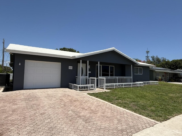 257 SW 5th St, Boca Raton, FL 33432 - ranch-style home featuring a porch, decorative driveway, an attached garage, a front lawn, and stucco siding