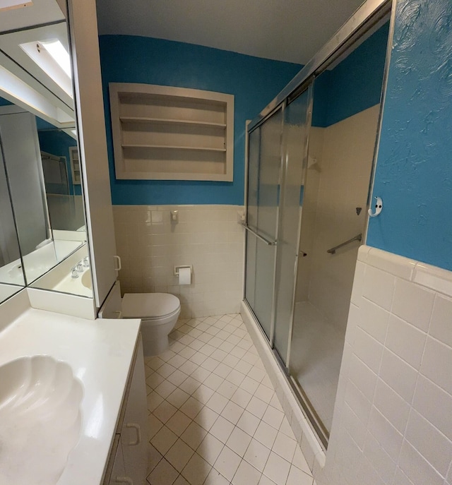 257 SW 5th St, Boca Raton, FL 33432 - bathroom with tile walls, a stall shower, wainscoting, tile patterned flooring, and toilet