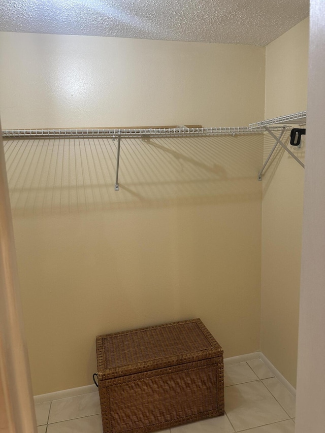 walk in closet with light tile patterned floors