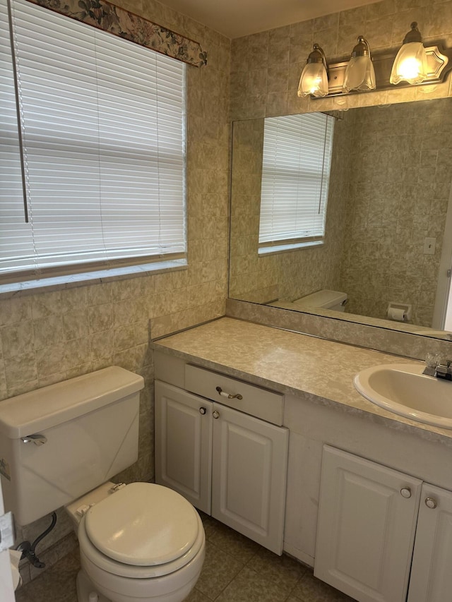 bathroom with toilet, vanity, and tile patterned floors