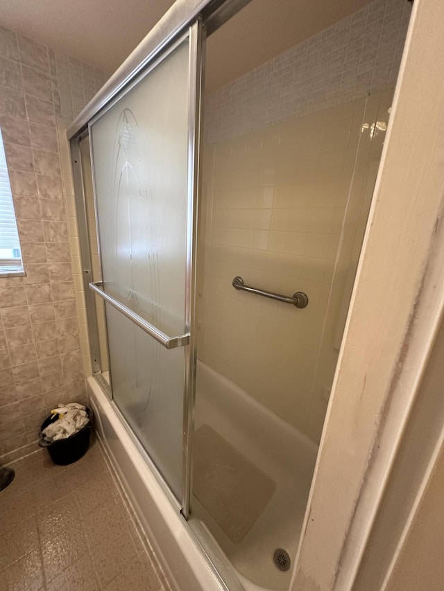 bathroom with enclosed tub / shower combo and tile walls