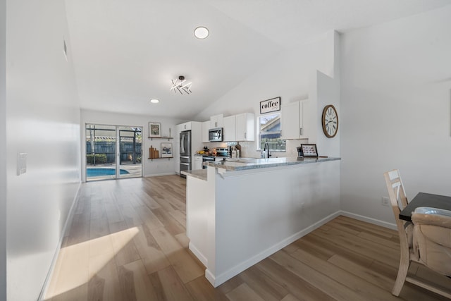 5157 Canal Cir S, Lake Worth, FL 33467 - kitchen featuring appliances with stainless steel finishes, white cabinets, light wood-style flooring, backsplash, and high vaulted ceiling