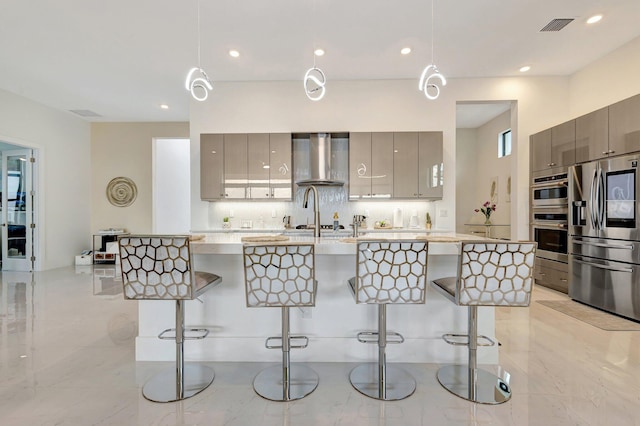 5320 Saint Armands Way, Westlake, FL 33470 - kitchen featuring appliances with stainless steel finishes, modern cabinets, wall chimney range hood, a kitchen breakfast bar, and recessed lighting