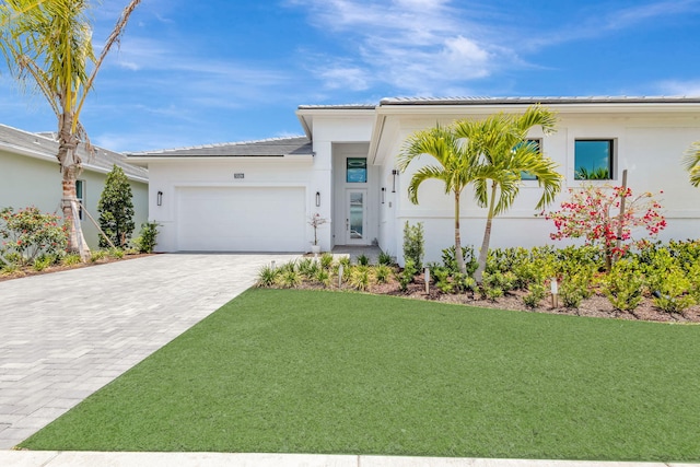 5320 Saint Armands Way, Westlake, FL 33470 - view of front facade featuring an attached garage, decorative driveway, a front lawn, and stucco siding