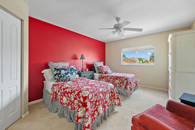 carpeted bedroom featuring ceiling fan, baseboards, and a textured ceiling