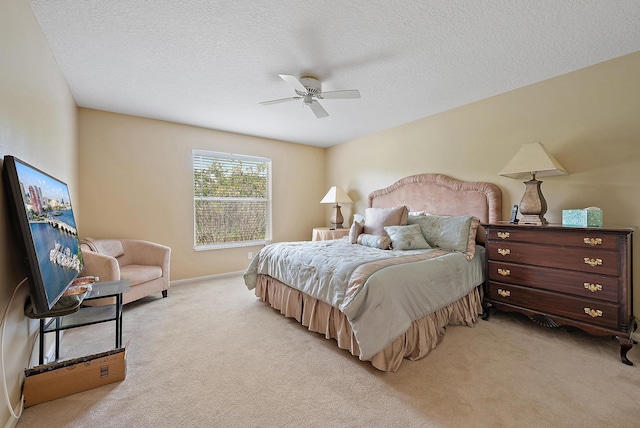 bedroom with light carpet, a textured ceiling, ceiling fan, and baseboards