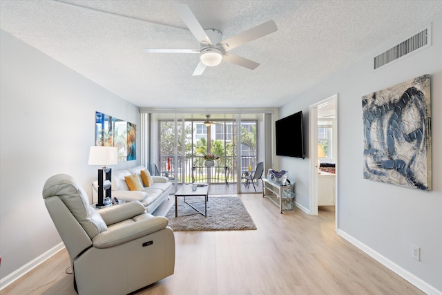 2016 S Federal Hwy Unit 206, Boynton Beach, FL 33435 - living area with a textured ceiling, a ceiling fan, light wood-type flooring, and baseboards