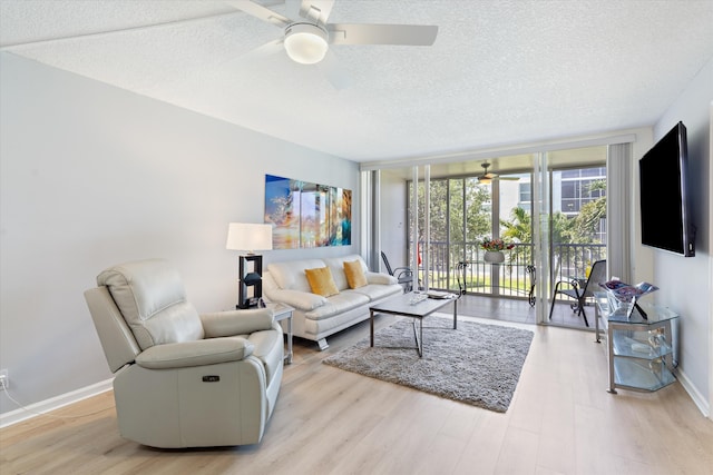2016 S Federal Hwy Unit 206, Boynton Beach, FL 33435 - living room featuring a ceiling fan, a textured ceiling, floor to ceiling windows, light wood-type flooring, and baseboards