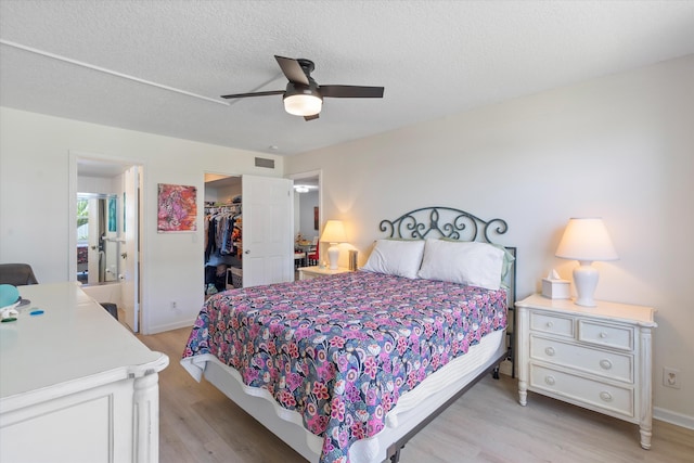 2016 S Federal Hwy Unit 206, Boynton Beach, FL 33435 - bedroom featuring light wood-type flooring, a spacious closet, a closet, ceiling fan, and a textured ceiling