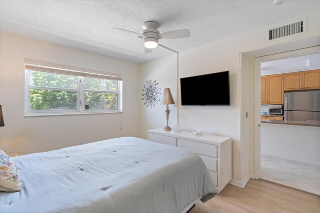 2016 S Federal Hwy Unit 206, Boynton Beach, FL 33435 - bedroom with freestanding refrigerator, light wood-type flooring, a textured ceiling, and ceiling fan