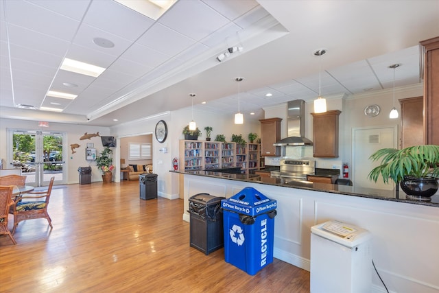 2016 S Federal Hwy Unit 206, Boynton Beach, FL 33435 - kitchen featuring wall chimney exhaust hood, stainless steel range with electric stovetop, a raised ceiling, light wood-type flooring, and decorative light fixtures