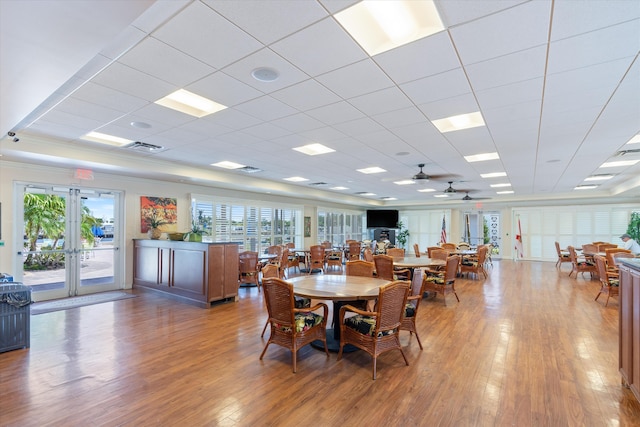 2016 S Federal Hwy Unit 206, Boynton Beach, FL 33435 - dining space featuring french doors, plenty of natural light, light wood-type flooring, a ceiling fan, and a paneled ceiling