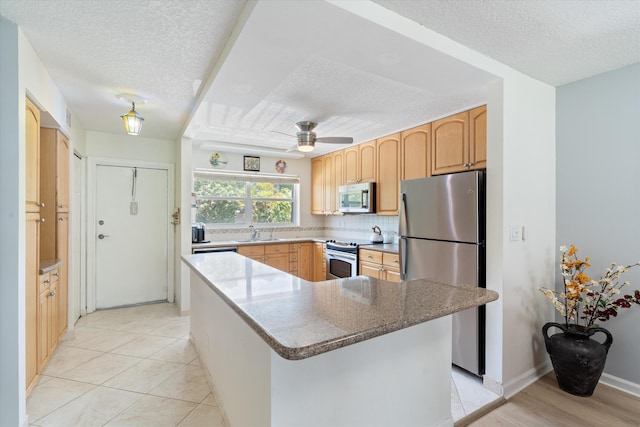 2016 S Federal Hwy Unit 206, Boynton Beach, FL 33435 - kitchen with appliances with stainless steel finishes, a textured ceiling, a sink, light brown cabinetry, and backsplash