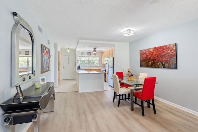 2016 S Federal Hwy Unit 206, Boynton Beach, FL 33435 - dining room with light wood-style floors, a textured ceiling, a ceiling fan, arched walkways, and baseboards