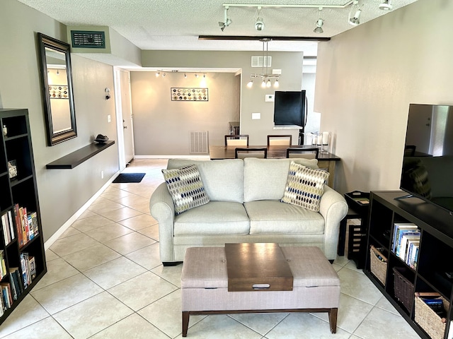 11231 Green Lake Dr Unit 104, Boynton Beach, FL 33437 - living room featuring track lighting, light tile patterned flooring, and a textured ceiling