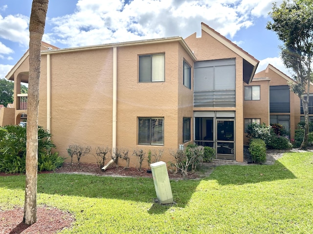11231 Green Lake Dr Unit 104, Boynton Beach, FL 33437 - rear view of house with stucco siding and a lawn