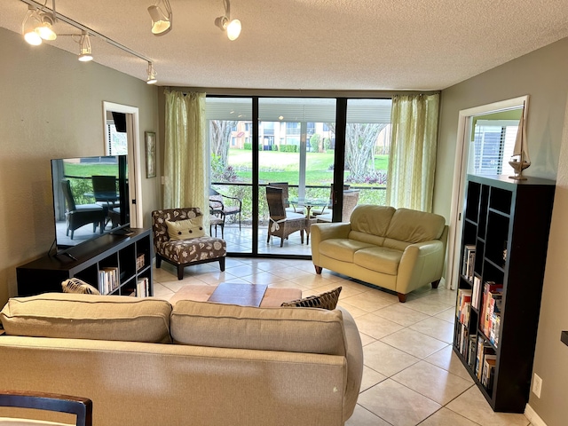 11231 Green Lake Dr Unit 104, Boynton Beach, FL 33437 - living room featuring light tile patterned floors, a textured ceiling, and a wall of windows