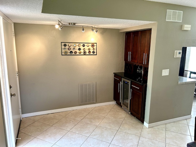 11231 Green Lake Dr Unit 104, Boynton Beach, FL 33437 - kitchen featuring wine cooler, a textured ceiling, light tile patterned floors, and rail lighting