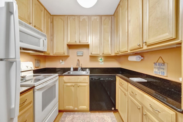 kitchen featuring white appliances, a sink, light brown cabinets, and light wood-style flooring