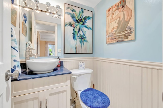 bathroom featuring wainscoting, vanity, and toilet