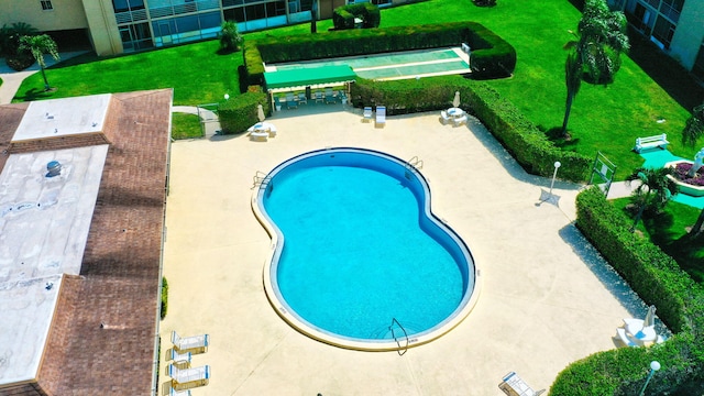 community pool featuring a patio and a lawn