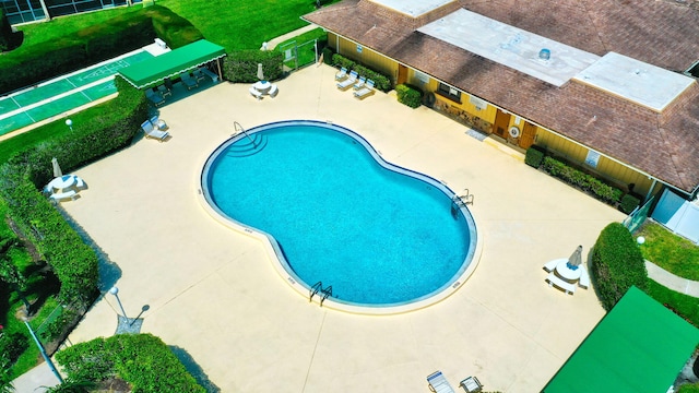 community pool featuring fence and a patio