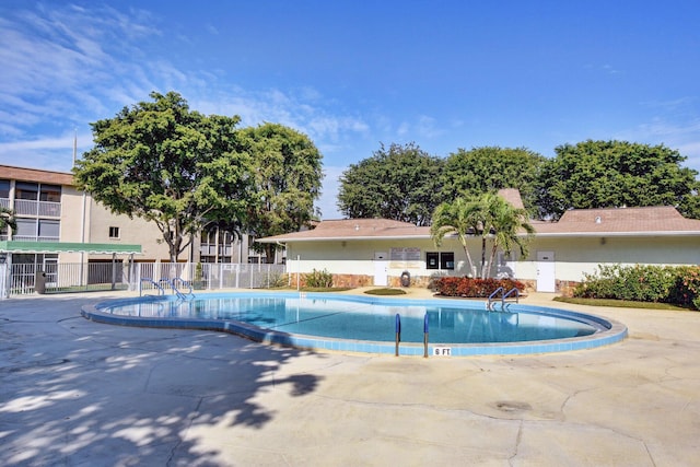 community pool featuring fence and a patio
