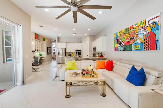 living room with a ceiling fan, recessed lighting, and baseboards