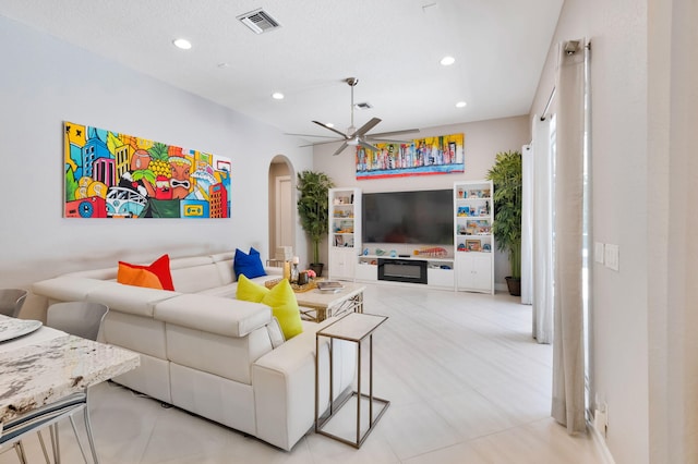 living area with arched walkways, ceiling fan, recessed lighting, and light tile patterned floors