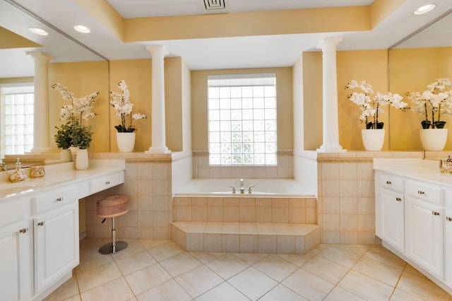 full bathroom with decorative columns, tile walls, tile patterned flooring, vanity, and a garden tub