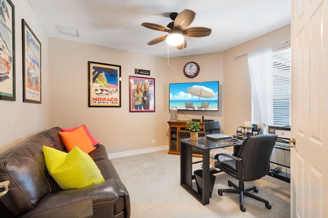 home office featuring light carpet, a ceiling fan, a textured ceiling, and baseboards