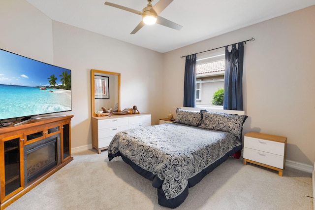 bedroom featuring light carpet, baseboards, and ceiling fan