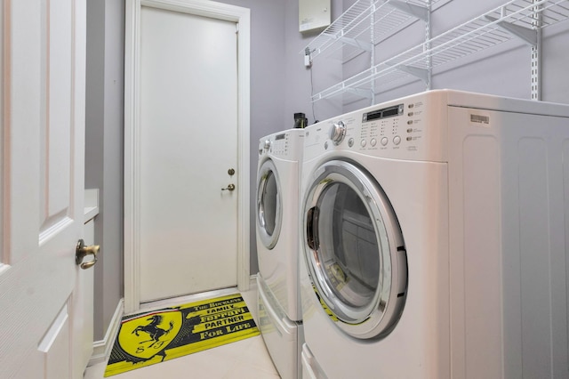 laundry area with washing machine and dryer and baseboards