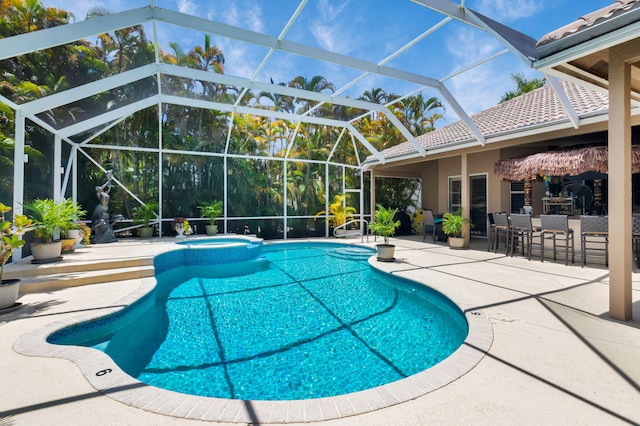 view of swimming pool with a patio area, a pool with connected hot tub, and a lanai