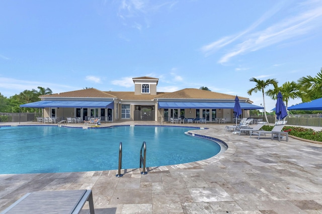 community pool with fence and a patio area