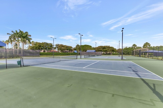 view of tennis court with fence and community basketball court