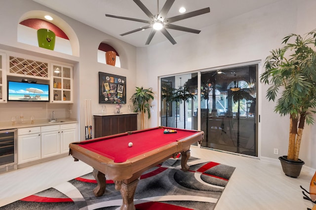 recreation room featuring beverage cooler, bar with sink, billiards table, ceiling fan, and baseboards
