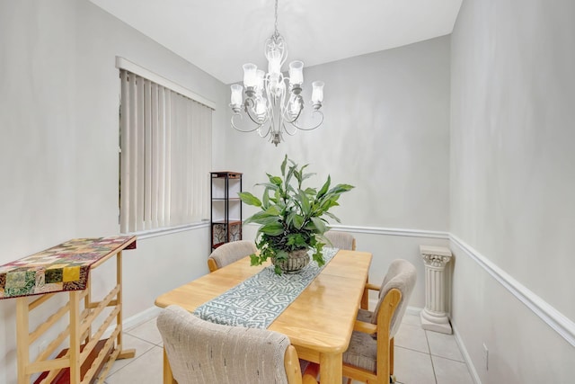 dining room with a chandelier, light tile patterned floors, and baseboards