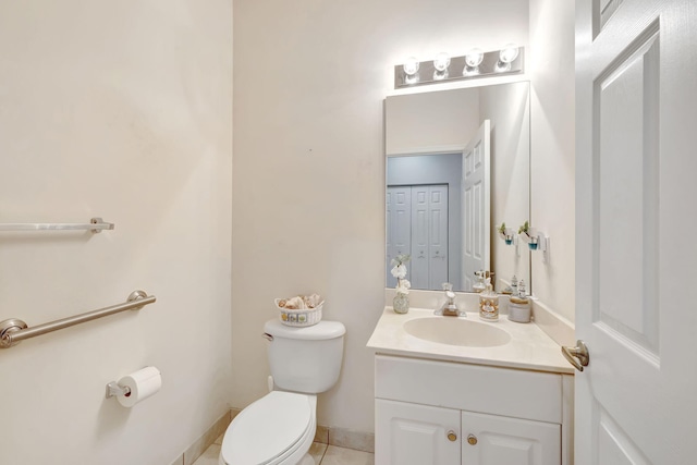 half bathroom featuring toilet, vanity, and tile patterned floors