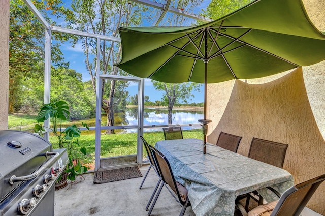 sunroom / solarium with a water view and outdoor dining space