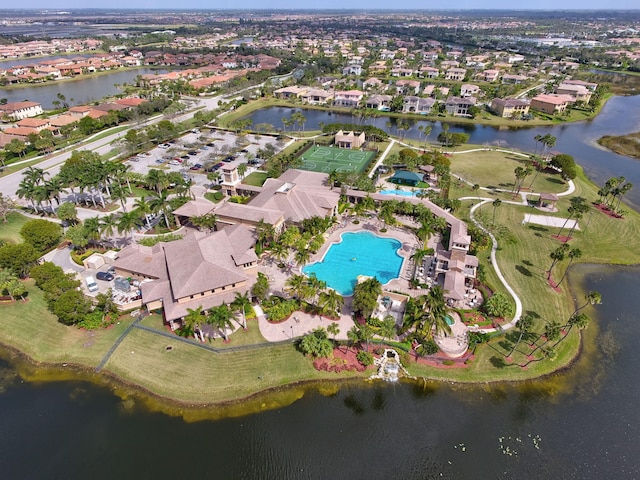 view of property location with a pool, a nearby body of water, and nearby suburban area