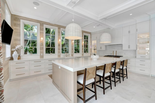 kitchen featuring coffered ceiling, beamed ceiling, white cabinetry, light countertops, and tasteful backsplash