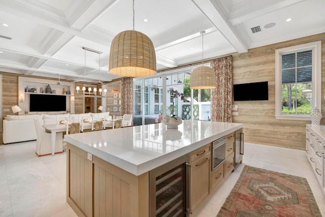 kitchen with open floor plan, wine cooler, coffered ceiling, plenty of natural light, and a center island