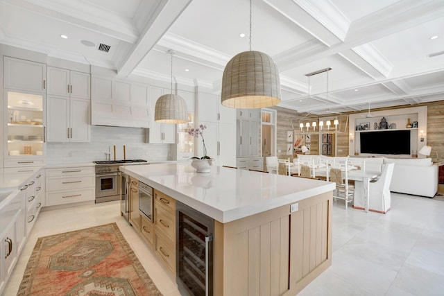kitchen with beverage cooler, high end range, coffered ceiling, beamed ceiling, and a spacious island