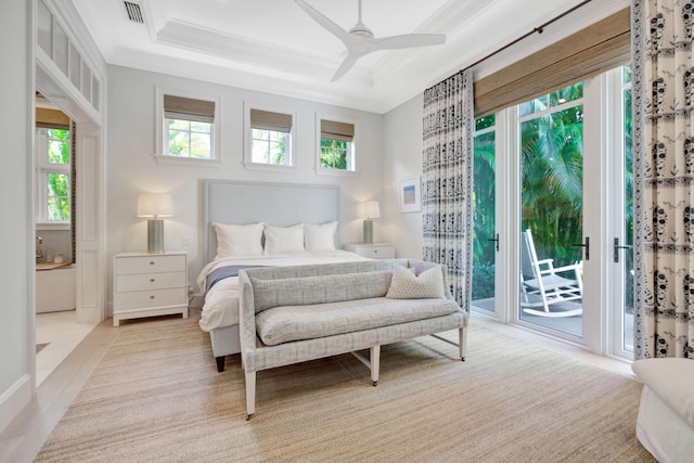 bedroom featuring access to outside, crown molding, a ceiling fan, and a tray ceiling