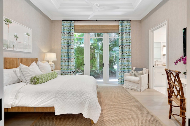 bedroom featuring ornamental molding, ensuite bath, coffered ceiling, a sink, and wood finished floors