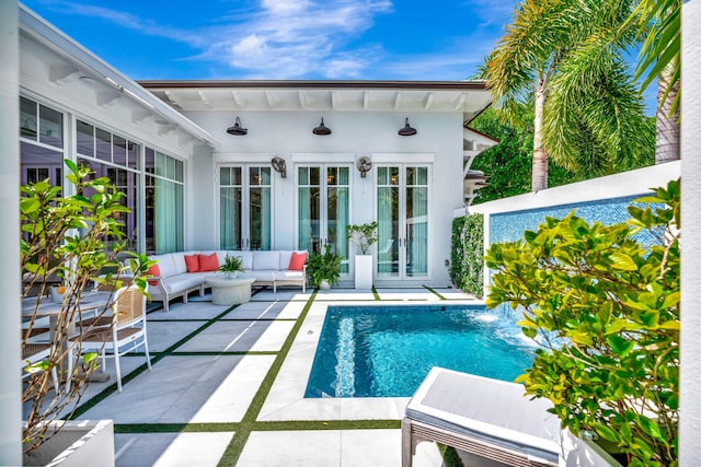 swimming pool featuring a patio, an outdoor living space, a storage structure, and an outbuilding