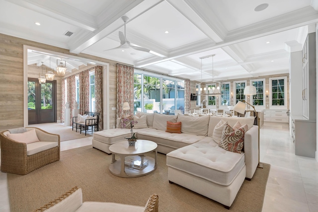 living area featuring coffered ceiling, a chandelier, beamed ceiling, ceiling fan, and crown molding