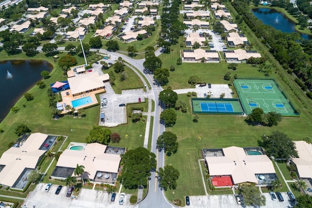 aerial view of property and surrounding area with a nearby body of water and nearby suburban area