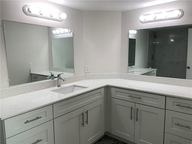 bathroom featuring a marble finish shower and vanity